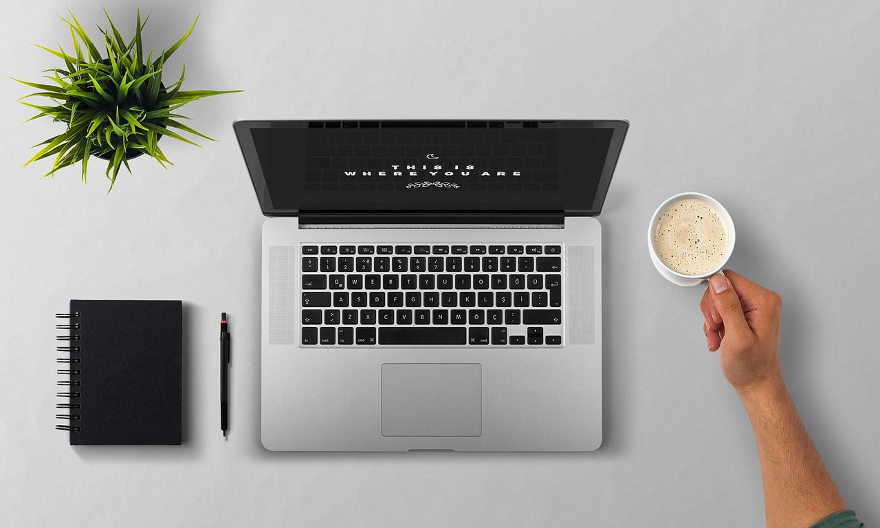 Laptop, coffee, arm — London Tantric Experts: Elevate Your Wellbeing Today